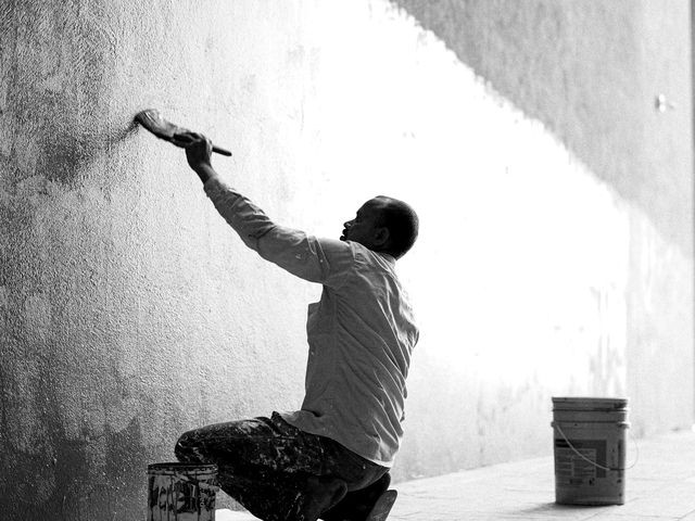Peintre appliquant un enduit sur un grand mur