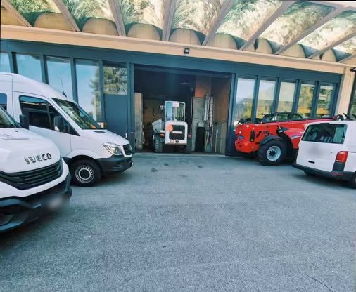 Les fourgons de l'entreprise et le chariot télescopique devant le dépôt